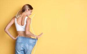 Waistband of oversized pants stretched to show weight loss progress.